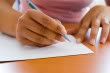 ©iStockphoto writing down a letter