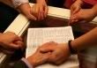 ©iStockphoto praying around the Bible